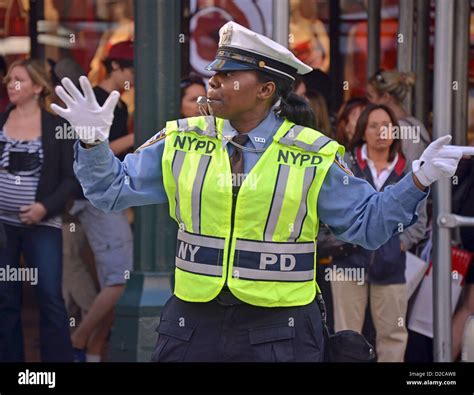 Female New York City Traffic Enforcement Officer directing cars at West 34th Street and Broadway ...