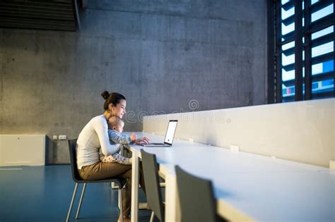 Estudiante Joven Con Un Beb Que Se Sienta En El Escritorio En Sitio En