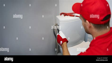 Plumber Working In Toilet Installing Water Pipe To Wc Tank Copy Space