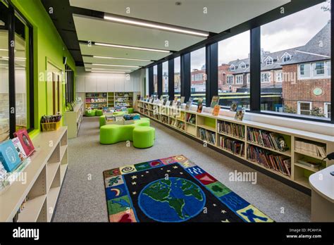 Library in new building. Thomas's Battersea, London, United Kingdom. Architect: Hugh Broughton ...