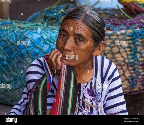 An Older Tzutujil Mayan Woman In Traditional Dress Sells Produce In The