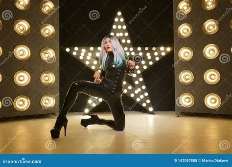 Hot Slim Woman Posing In Latex Rubber Fashion Clothes On Black Background With Yellow Lights