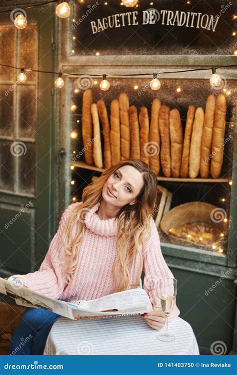 Fashionable And Beautiful Blonde Model Girl In Trendy Oversize Sweater Sit With Newspaper And