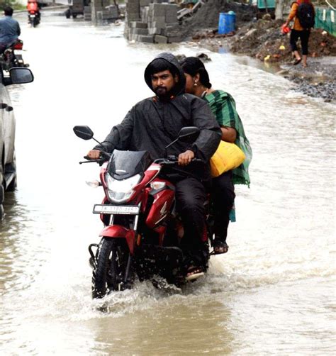 Vehicles Navigate A Waterlogged Road After Heavy Rainfall