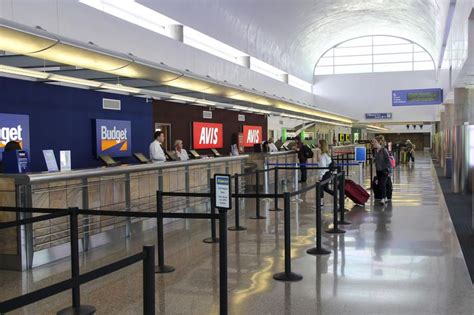 an airport with people waiting for their luggage