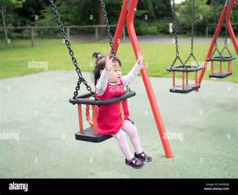 baby girl playing swing at the playground Stock Photo - Alamy