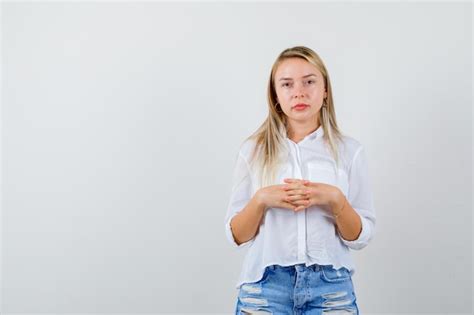 Junge blonde frau in einem weißen hemd Kostenlose Foto