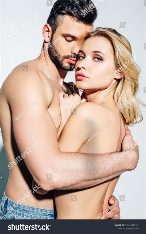 Стоковая фотография 1394610197 Shirtless Man Hugging Naked Blonde