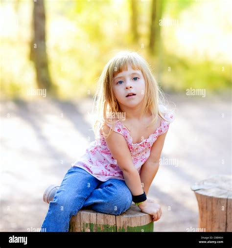 blonde junge Mädchen im Baumstamm Wald im freien Stockfotografie Alamy
