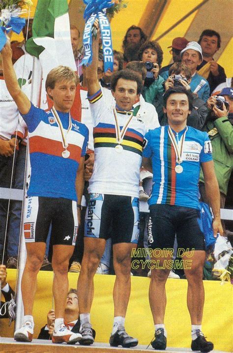 Three Men Standing On Top Of A Podium Holding Up Their Medals