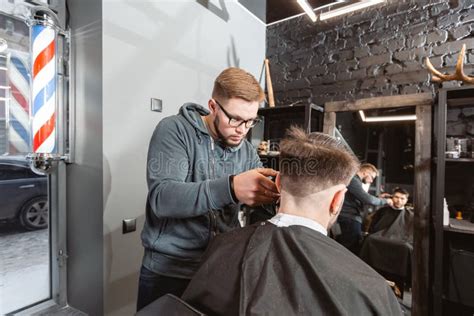 Master Cuts Hair And Beard Of Men In The Barbershop Hairdresser Makes