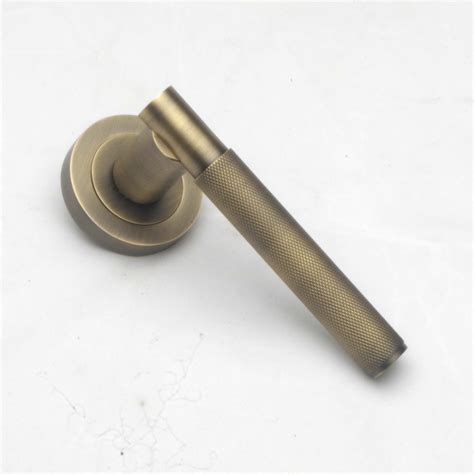 Brushed Aged Brass Knurled Lever Handles On Rose The Door Knocker Company