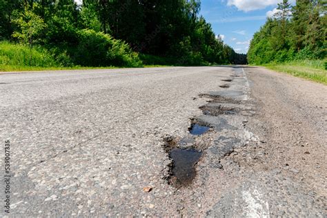 Poor quality road with potholes. Holes in the roadway. Risk of driving ...