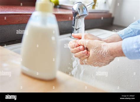 Elderly Woman Washing Hands With Liquid Soap At Home At The Sink Stock