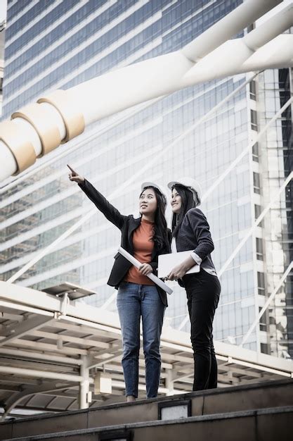 Dois Jovens Arquitetos Que Olham O Modelo Em Frente Ao Edif Cio Do