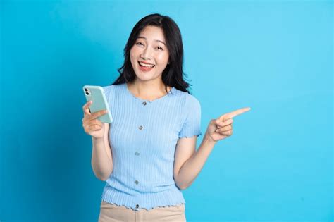 Premium Photo Portrait Of Smiling Asian Woman Posing On Blue Background