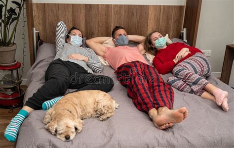 Familia Enferma Con Máscaras Protectoras En La Cama Foto de archivo