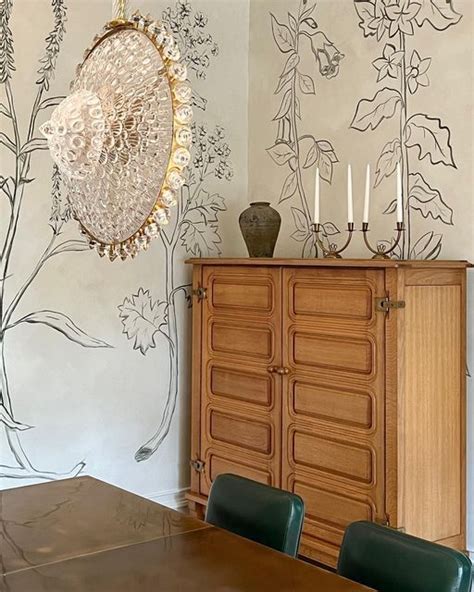 A Dining Room Table With Chairs And A Vase On Top Of It Next To A Wall