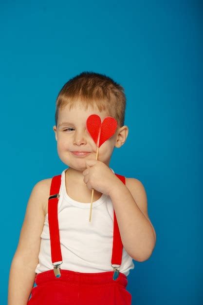 Niño lindo en tirantes rojos en el día de san valentín Foto Premium