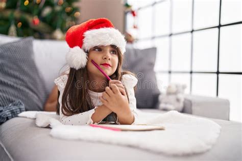 Adorable Hispanic Girl Smiling Confident Lying On Sofa By Christmas