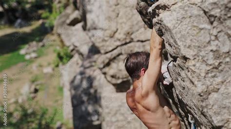 Slow Motion Top View Of An Athletic Arab Or Hindu Man Rock Climber With Naked Torso Climbs On A