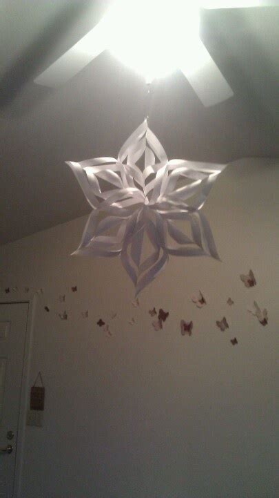 A Paper Snowflake Hanging From The Ceiling In A Room With Butterflies