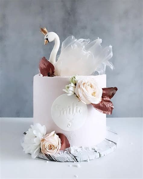 A Wedding Cake Decorated With Flowers And Swans