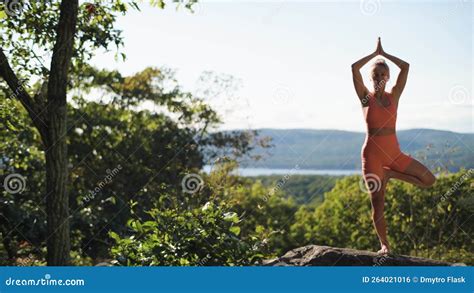 Woman Is Practicing Yoga In Tree Pose At A Beautiful Exotic Place On