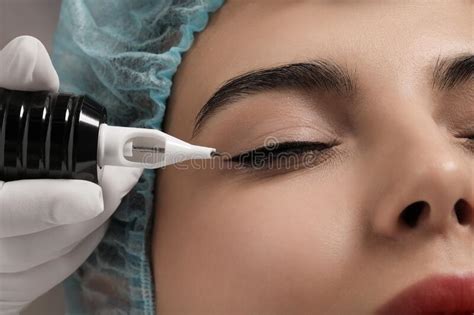 Young Woman Undergoing Procedure Of Permanent Eyeliner Makeup Closeup