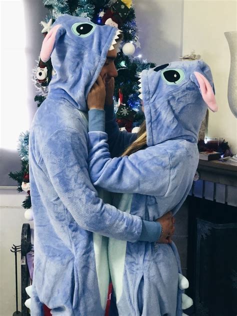 Two People In Blue Costumes Hugging Near A Christmas Tree