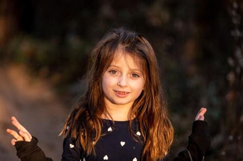 Premium Photo Portrait Of Cute Girl Smiling While Standing Outdoors