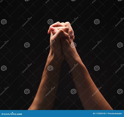 Hands Of Man And Woman Clasped Together At Black Background Stock Image