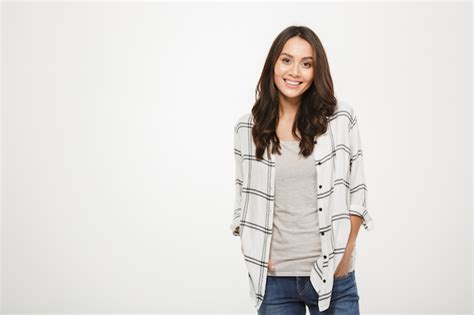 Free Photo Smiling Brunette Woman In Shirt Posing With Arms In Pockets And Looking At The