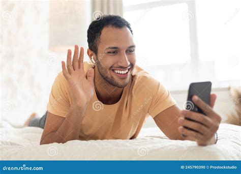 Happy Arabic Male Making Video Call On Smartphone At Home Stock Photo