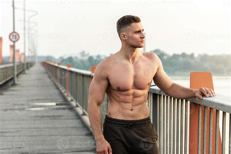 Muscular Man With Naked Torso During Fitness Workout On A Bridge