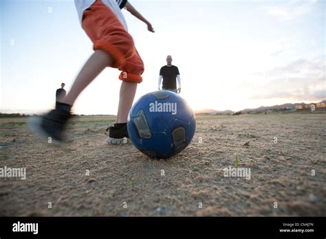 Kicking soccer ball Stock Photo - Alamy