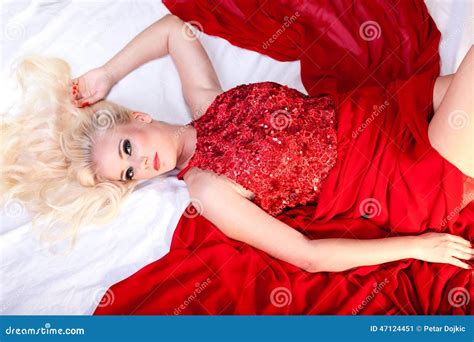 Elegant Blonde Woman In Long Red Dress Lying On The Bed Stock Image Image Of Desire