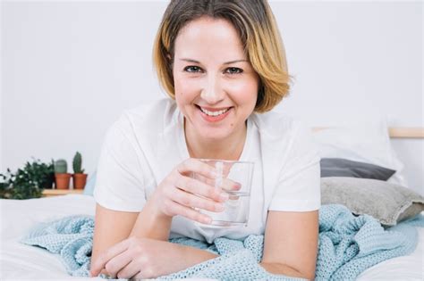 Sorrindo mulher água na cama Foto Grátis