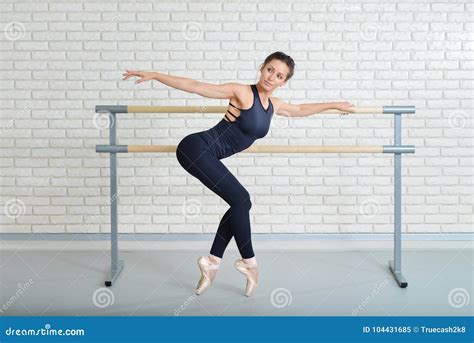 Ballerina Stretches Herself Near Barre At Ballet Studio Full Length