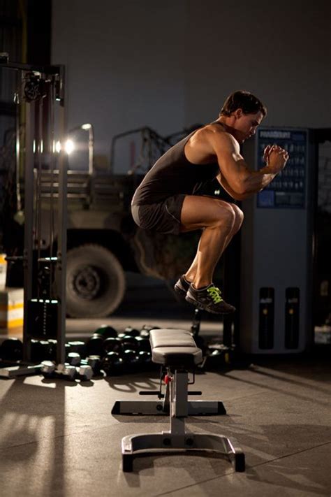 A Man Jumping Over A Bench In The Middle Of A Crossfit Exercise Area