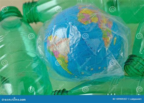 Earth Globe In Plastic Bag Among Plastic Bottles Concept Of Ecology
