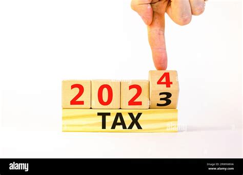 2024 Tax New Year Symbol Businessman Turns A Wooden Cube And Changes