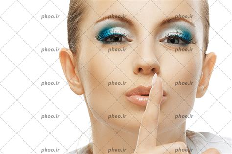 عکس زن با موهای تیره و آرایش صورت زیبا و انگشت اشاره بر روی لب دارد