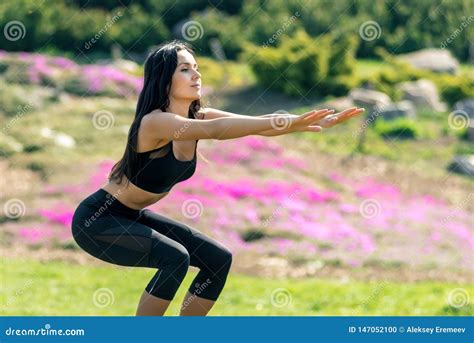 Slender Beautiful Girl With Dark Hair In A Sports Uniform Crouches In