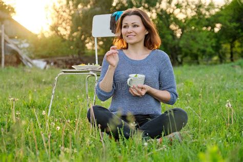 Happy Mature Woman Gardener Resting Sitting On Grass With Cup Of Tea Stock Photo Image Of
