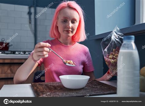 Woman With Pink Hair Eating Corn Flakes Cereal While Sitting And Having