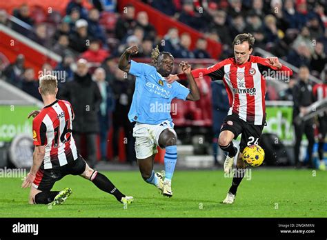 Jérémy Doku of Manchester City is stopped by Mikkel Damsgaard of