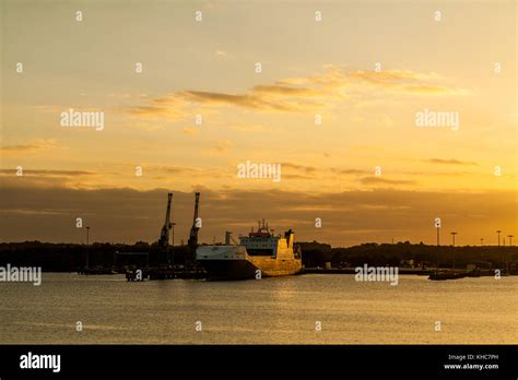 Sunset with cargo ship Stock Photo - Alamy