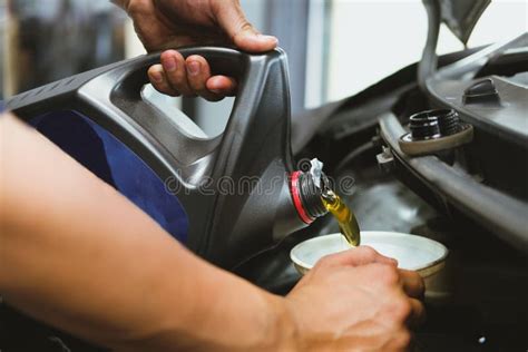 Mechanic Pouring Oil To Vehicle Engine Serviceman Changing Motor Oil