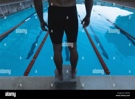 Male Swimmer Standing Standing On The Starting Block In Front Of The